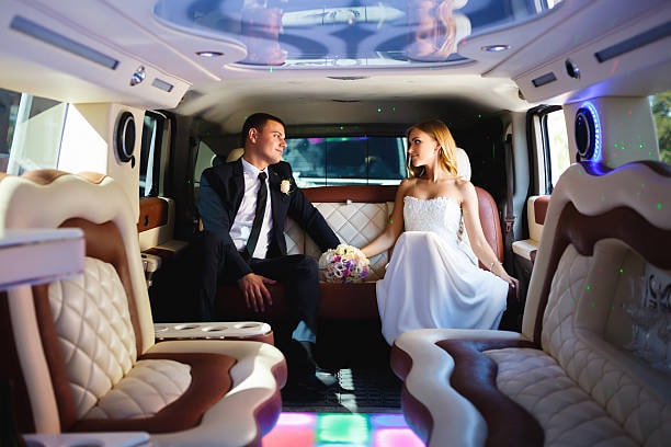 A couple enjoying their big day in a wedding limo. 