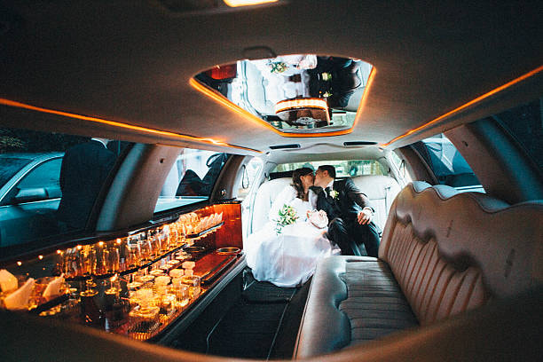 A couple celebrating thir special day in a wedding limo. 